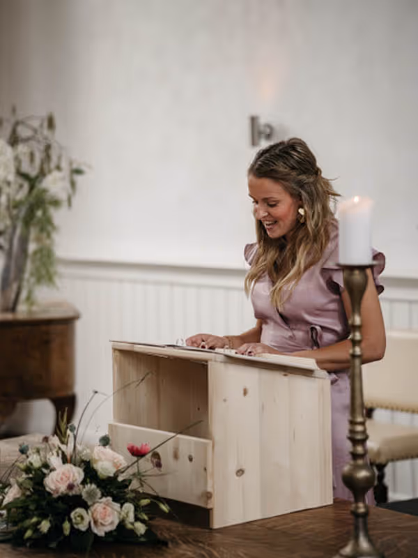 Lisanne staat achter katheder en spreektbruidspaar toe